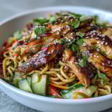 Tender chicken and fresh vegetables fill this Asian Chicken Noodle Bowl, garnished with sesame seeds and cilantro for a quick weeknight dinner.