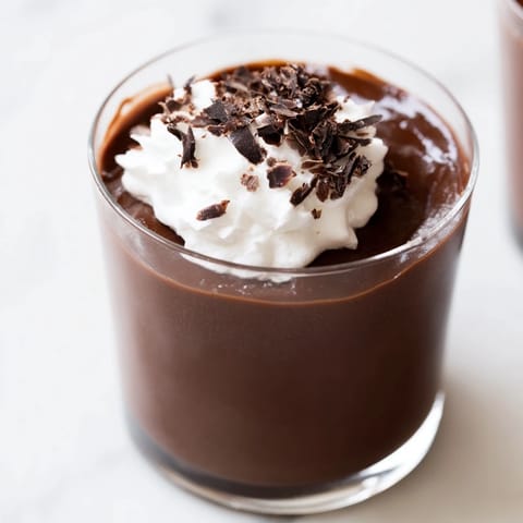 Homemade Chocolate Pudding with a smooth texture, resting on a marble countertop alongside a vintage spoon. 
