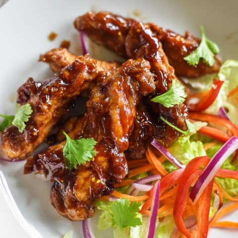 A close-up of a sliced Honey Sriracha Chicken Wrap showing tender chicken and colorful, crunchy vegetables inside.  