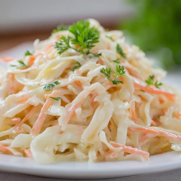 Chilled Coleslaw with Apple served as a side dish next to grilled chicken, highlighting its sweet, tangy, and refreshing flavors.