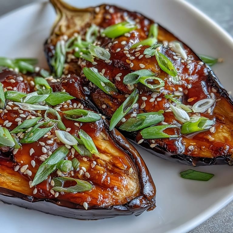 Tender miso glazed eggplant garnished with toasted sesame seeds and green onions, a classic umami-rich Japanese side dish.