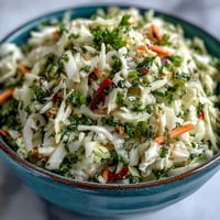 Fermented cabbage, crisp carrots, and red bell peppers tossed in a tangy vinaigrette in this fresh Sauerkraut Slaw.